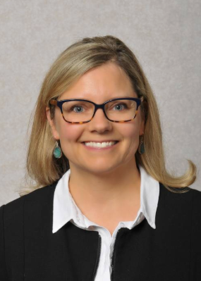 A headshot of a blonde smiling woman wearing glasses. Her name is Amy Darragh.